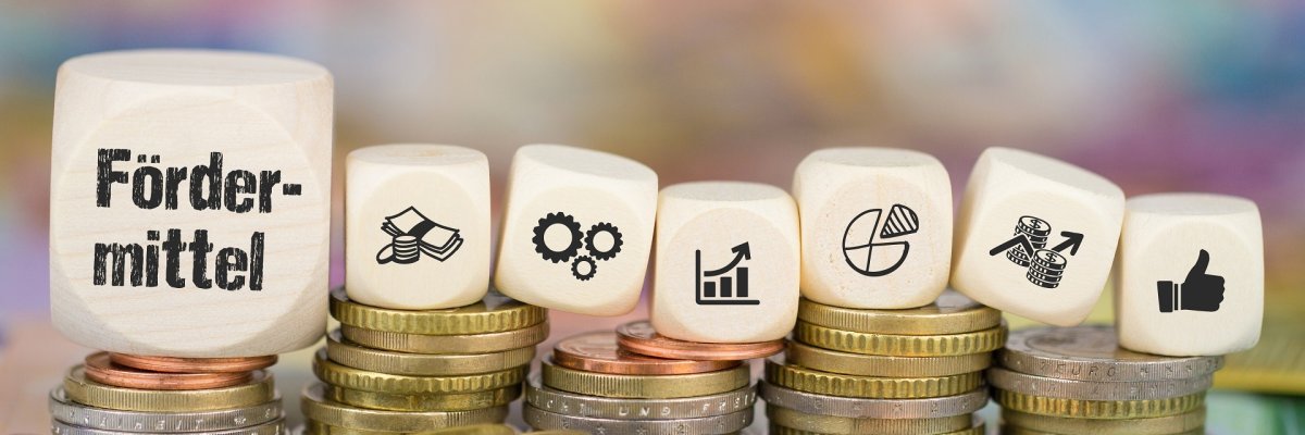 Fördermittel auf Münzenstapel Fördermittel auf Münzenstapel