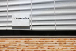 leerstehendes Ladenlokal An einem Schaufenster mit heruntergelassenen, weißen Jalousien klebt ein Hinweisschild mit dem Aufdruck "zu vermieten".
