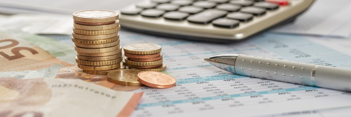 Geld mit Taschenrechner und Kugelschreiber