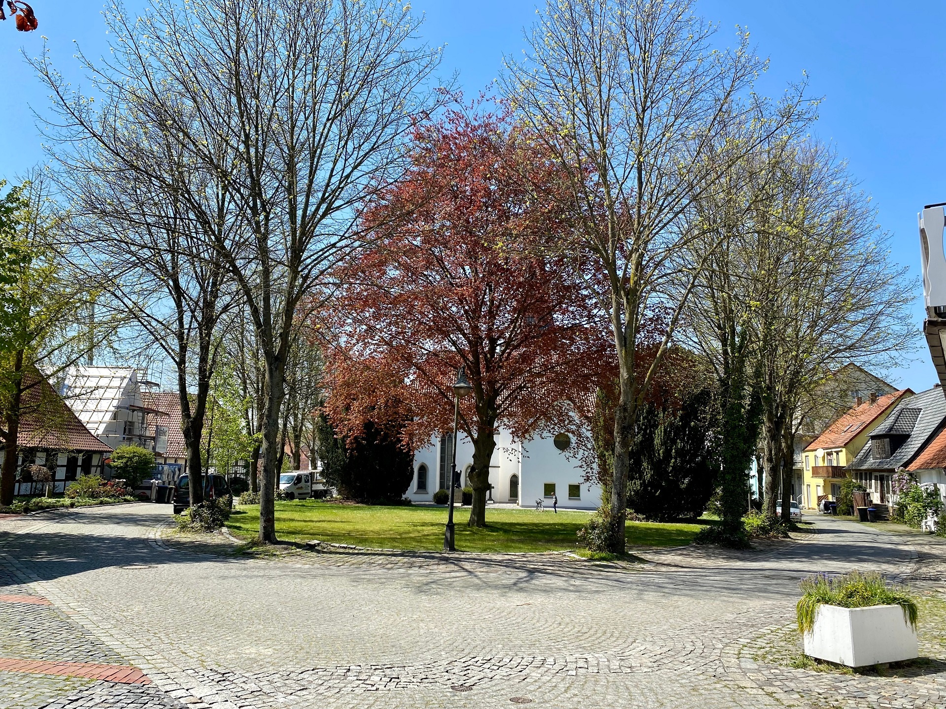 Eine in eine Art Parklandschaft eingebettete weiße Kirche. 