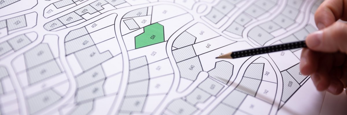 Human Hand Holding Pencil Over Cadastre Map Human Hand Holding Pencil Over Cadastre Map