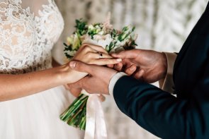 Heiraten Ringetausch Großaufnahme eines Brautpaares, das gerade die Ringe tauscht.