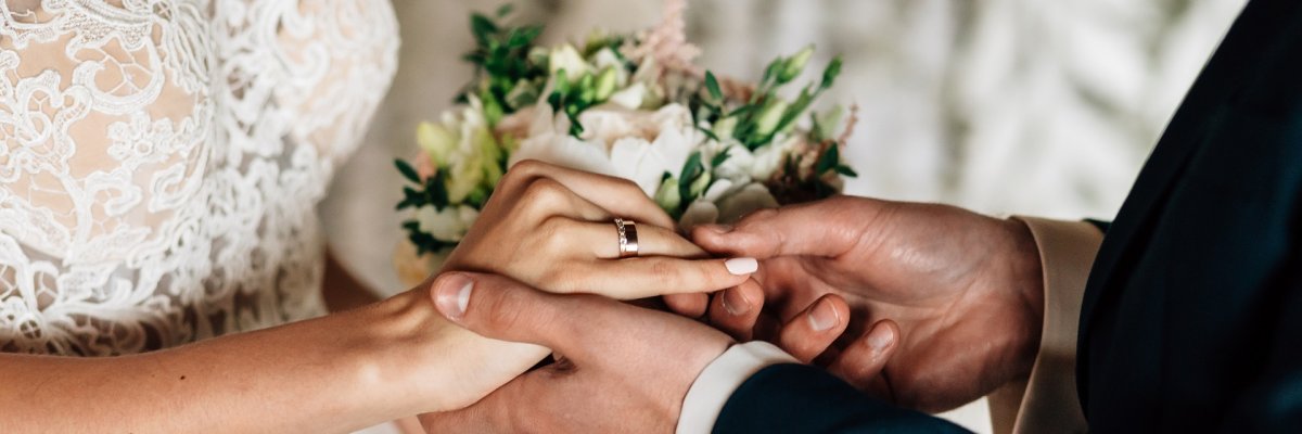 Heiraten Ringetausch Großaufnahme eines Brautpaares, das gerade die Ringe tauscht.