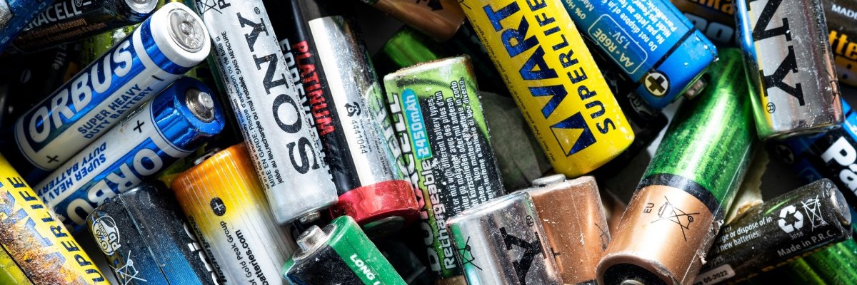 Close up shot of Stack of various batteries Eine Nahaufnahme eines Batteriebehälters, in dem etliche Batterien liegen.