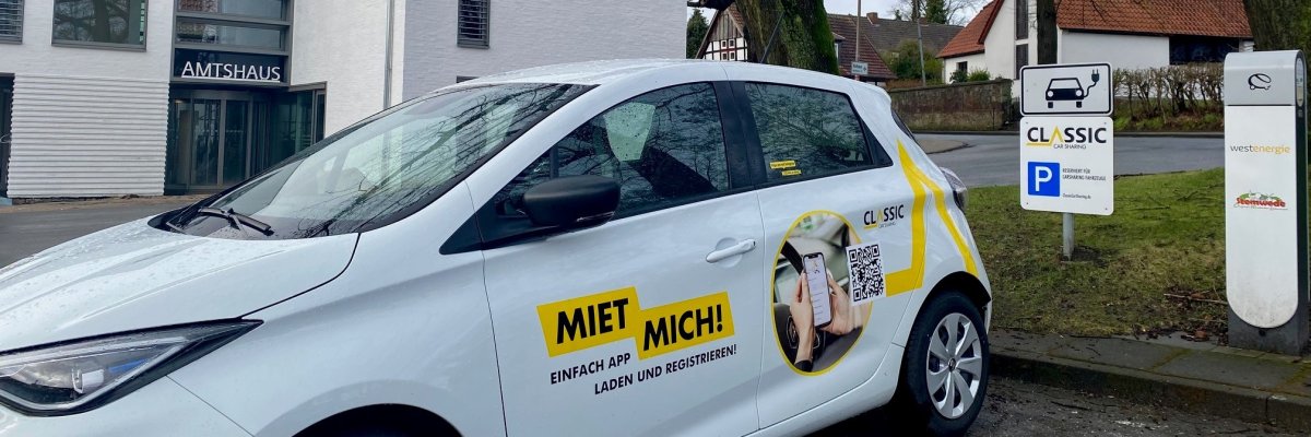 Ein weißes E-Auto an einer Ladesäule vor dem Amtshaus in Levern. 