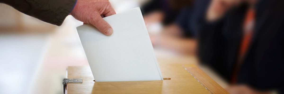 Stimmzettel in Wahlurne Stimmzettel in Wahlurne