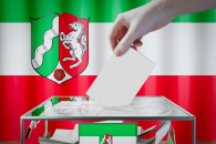 North Rhine-Westphalia flag, hand dropping ballot card into a box - voting/ election in Germany concept - 3D illustration North Rhine-Westphalia flag, hand dropping ballot card into a box - voting/ election in Germany concept - 3D illustration