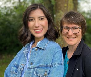 Drei Frauen, die in die Kamera lächeln.