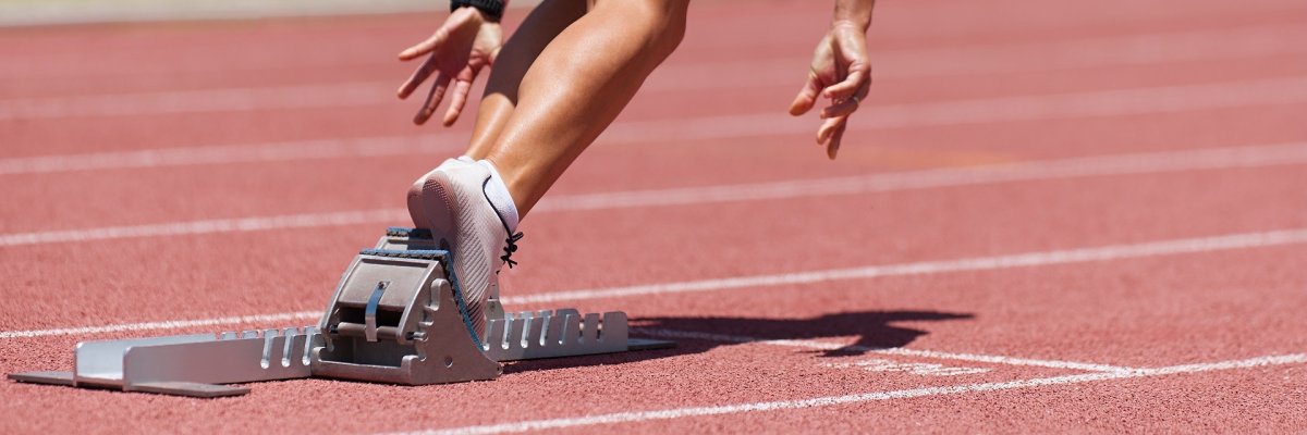 Athlete female feet on starting block ready for a sprint start Athlete female feet on starting block ready for a sprint start
