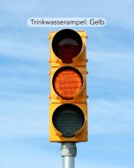 Eine Ampel, deren gelbes Licht in der Mitte orange leuchtet.
