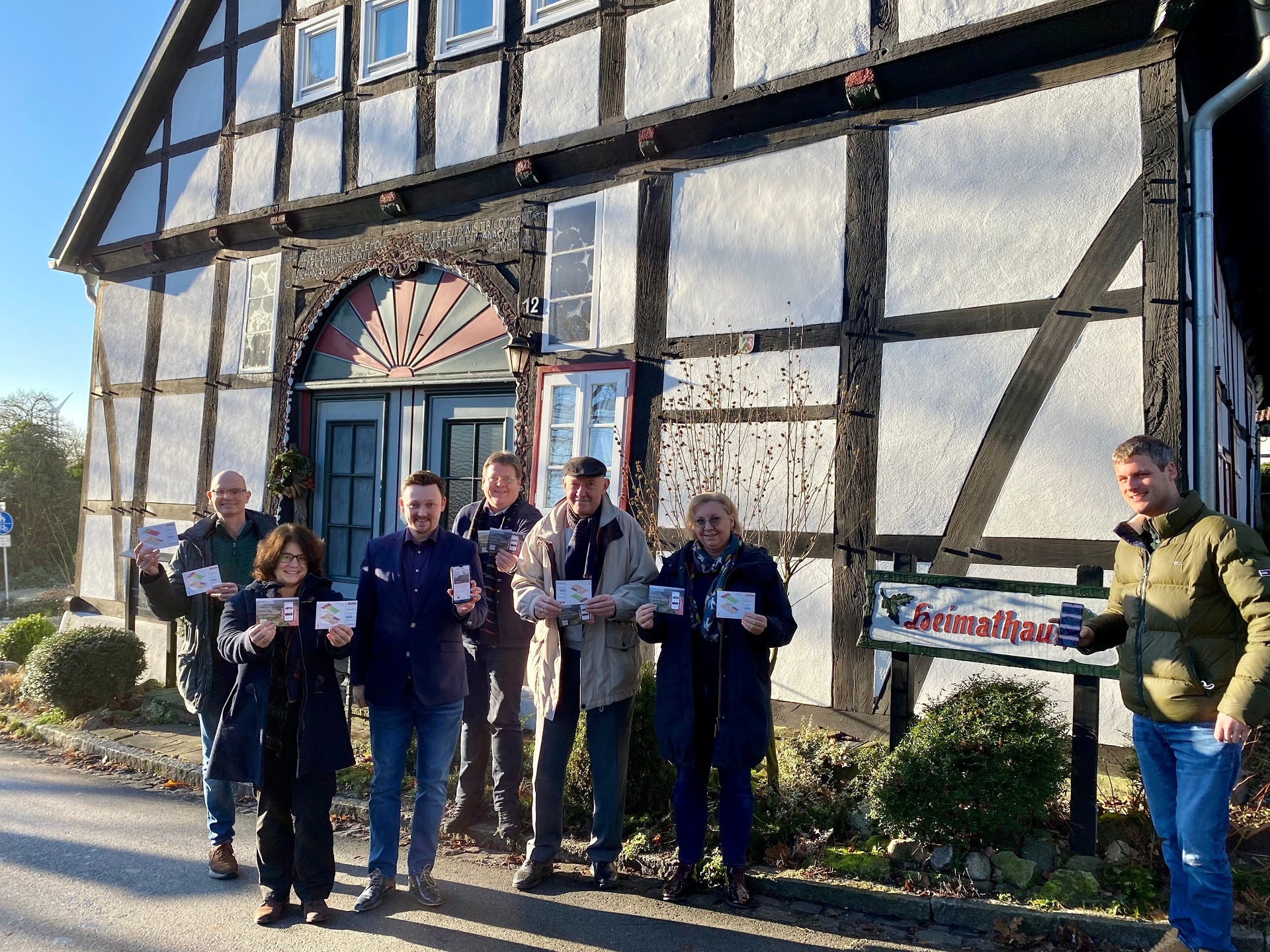 Eine Gruppe von Menschen steht vor einem historischen Fachwerkhaus.
