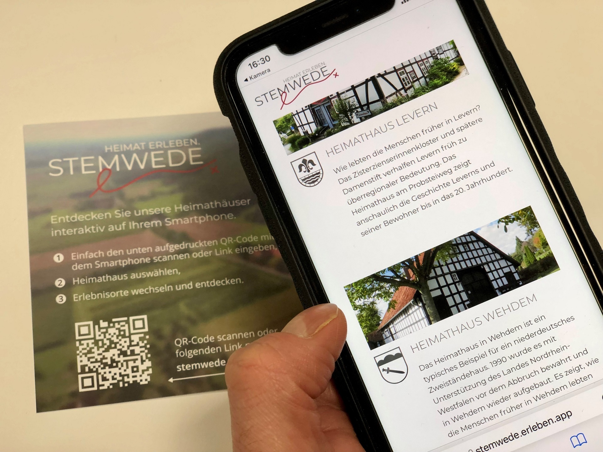 Eine Hand hält ein Smartphone, auf dem die neue App zu sehen ist. 