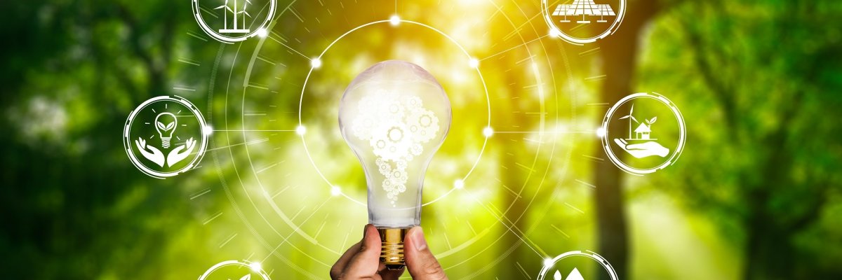 Eine Hand hält symbolische eine leuchtende Glühbirne. Im Hintergrund ist Natur zu sehen sowie verschiedene Symbolbilder, die aufs Energiesparen hindeuten. 