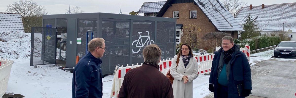Eine Gruppe von Menschen steht auf einem verschneiten Platz. 