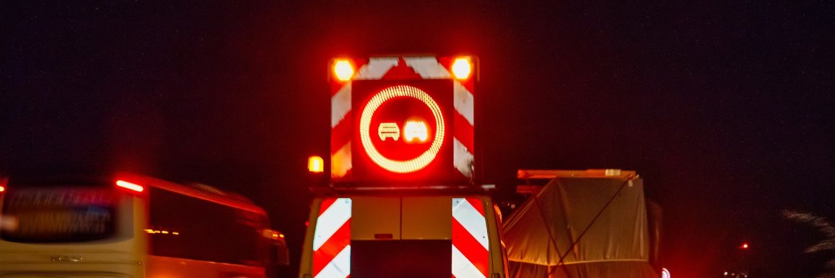 Absicherung eines Schwertransportes Ein Schwertransporter, der nachts auf einer Autobahn unterwegs ist und durch ein Begleitfahrzeug abgesichert wird.