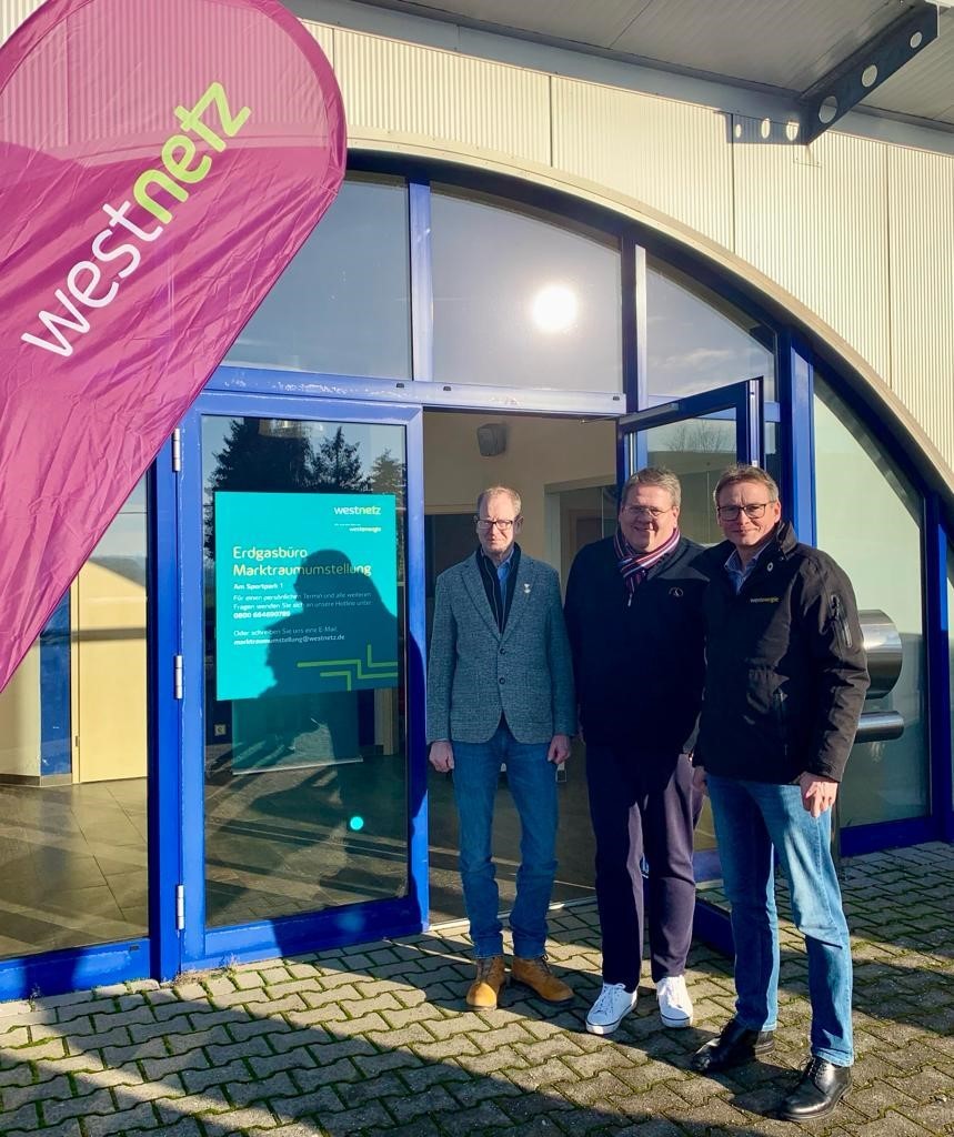  Drei Männer vor einem Geschäft.