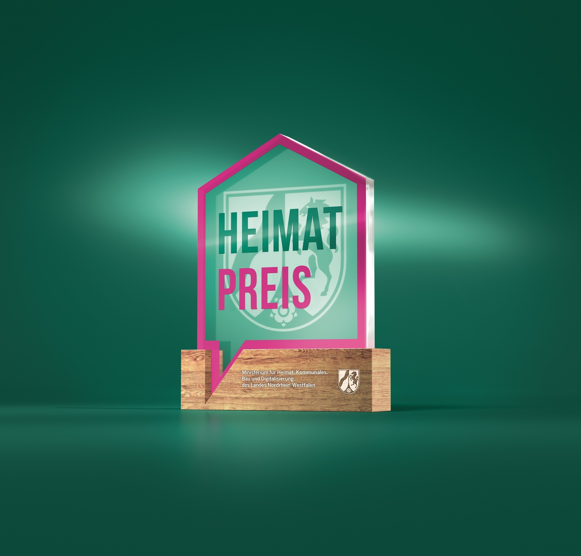 Eine gläserne Trophäe auf einem hölzernen Fuß. Mit grüner und magentafarbener Schrift ist Heimat-Preis-NRW zu lesen.