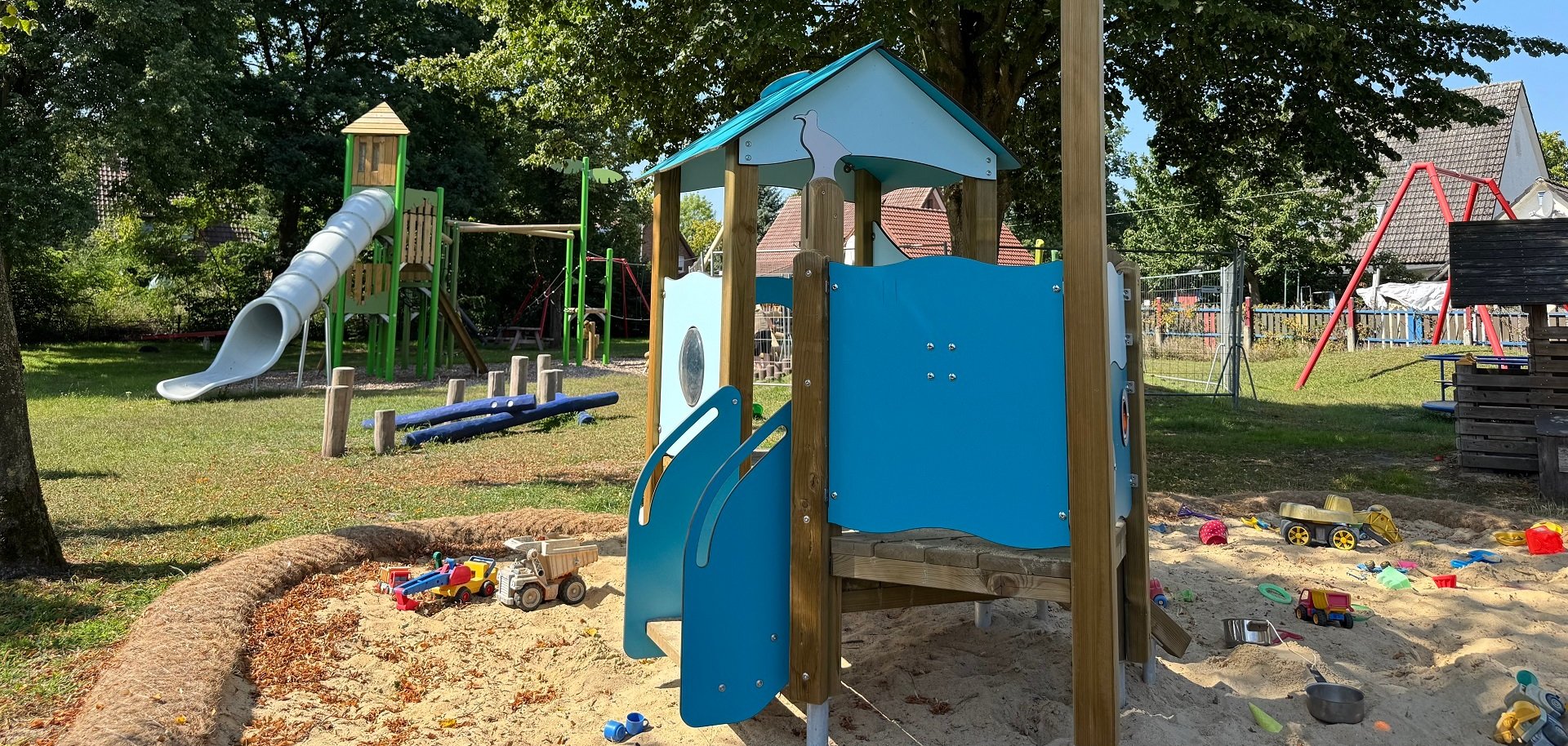 Ein Spielelement in einem Sandkasten auf einem Spielplatz, das aussieht, wie ein kleines Piratenschiff.
