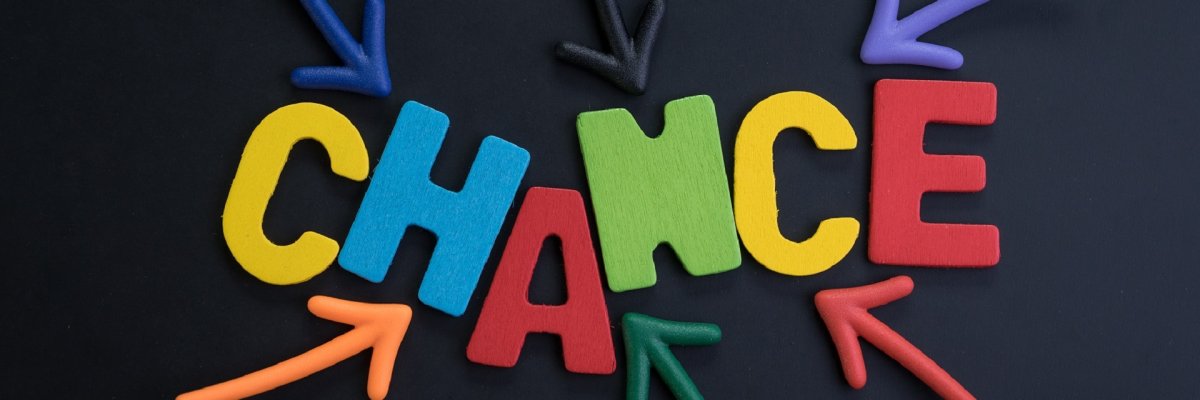 Chance Symbolbild: Bunte Buchstaben die das Wort Chance zeigen auf schwarzem Hintergrund.