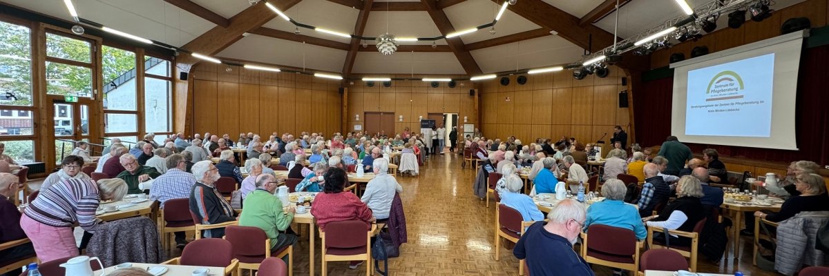 Infonachmittag Ein Veranstaltungssaal, in dem vielen Seniorinnen und Senioren bei Kaffee und Kuchen an Tischen sitzen.
