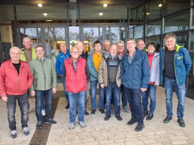Tourguides 2026 Ein Gruppenfoto mit 13 Männern und einer Frau vor dem Eingang eines Schulgebäudes.