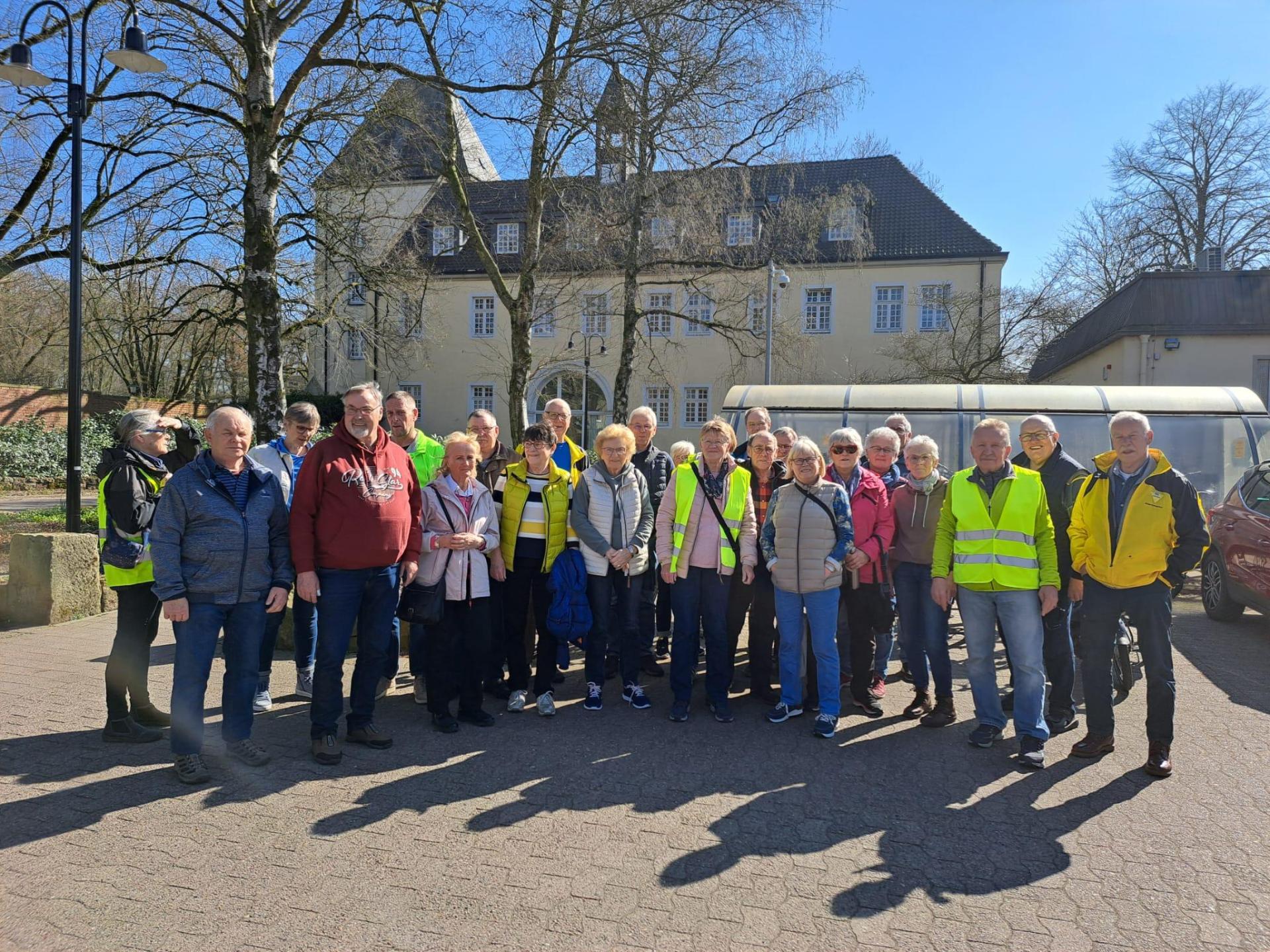 ZWAR Eine Gruppe von Personen, die zum Teil Warnwesten tragen, stehen vor einem historischen Gebäude.