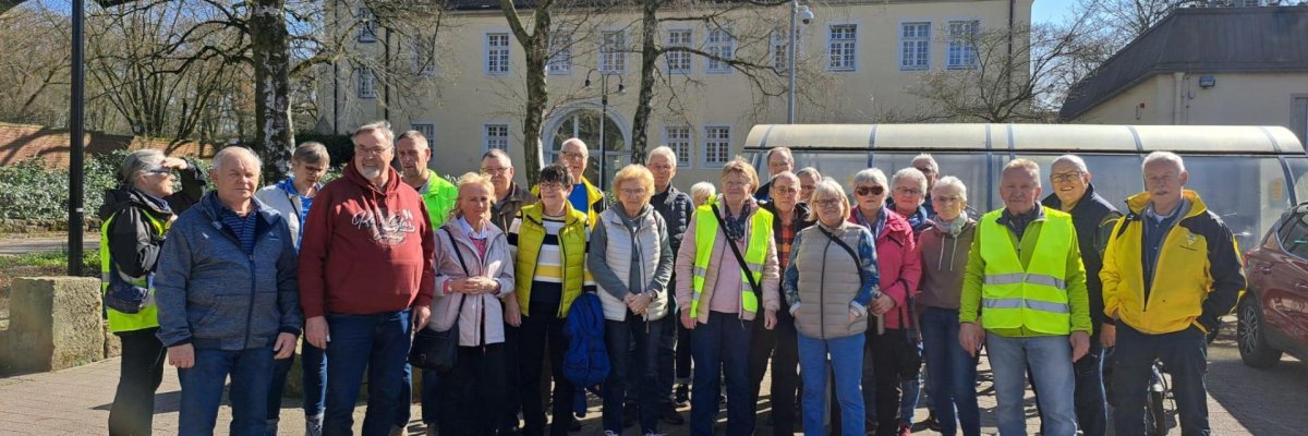 ZWAR Eine Gruppe von Personen, die zum Teil Warnwesten tragen, stehen vor einem historischen Gebäude.